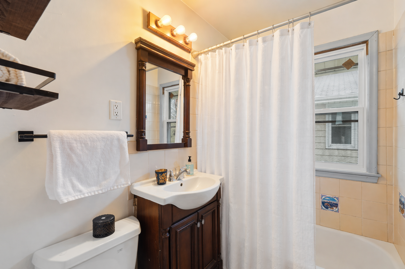 Main level full bath with a new vinyl window and charming Mediterranean-inspired tile details