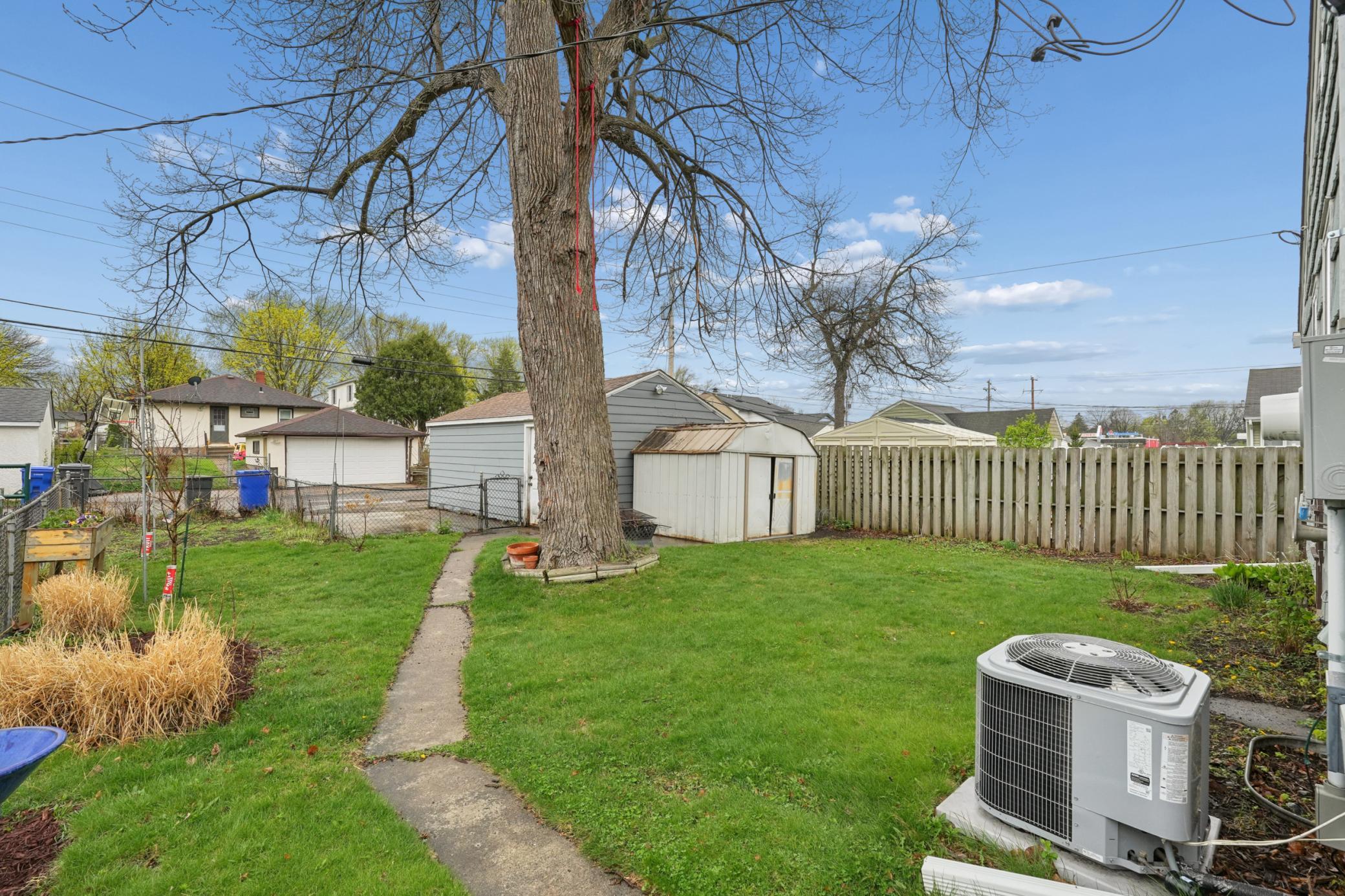 A fully fenced yard offering garden space, a fire pit, and a storage shed. Enjoy the apple and pear trees. Exterior updates also include a 2025 roof, soffits, and gutters and a newer AC.