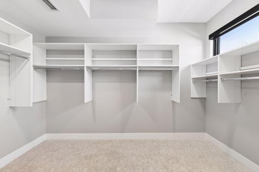 Primary bedroom walk-in closet with built-in organizational components