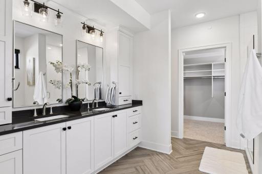 This luxurious spa-like bath features heated floors, separate tub and walk-in shower, and a spacious walk-in closet