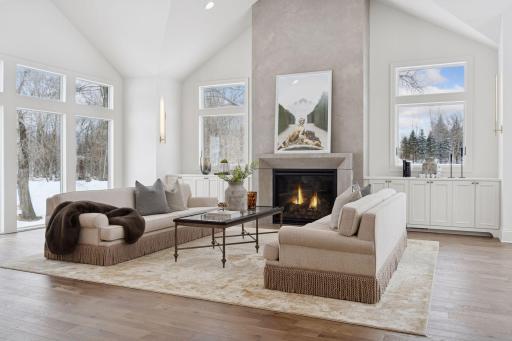 Formal living space with luxurious fireplace and plentiful windows.