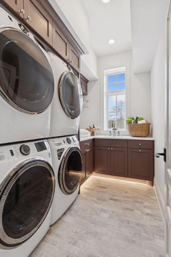 Upstairs laundry with double washer/dryer and sink.
