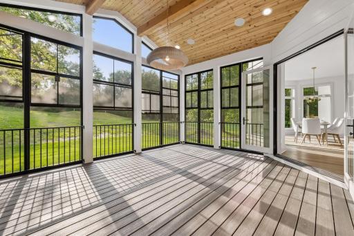 Three season porch offers vaulted ceilings, cozy gas fireplace, and stunning views of the private lot