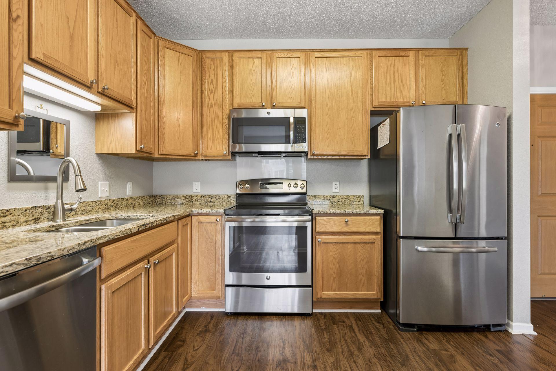 Efficient kitchen offers natural wood cabinetry, amble storage, work space, a pantry and pull-out drawers.
