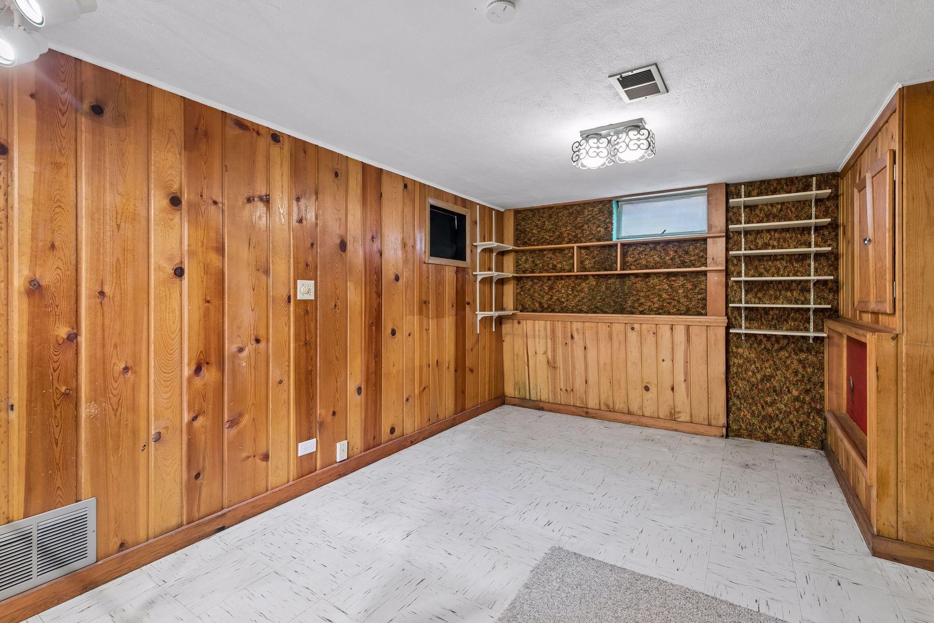 Lower level den, could be 4th bedroom with egress window. Featuring tile floor, overhead lights and built in storage.