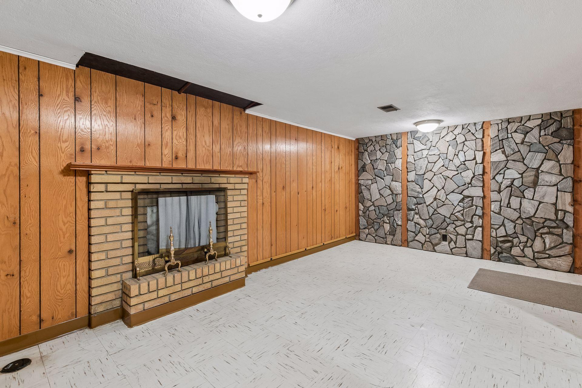 Relax or entertain in this inviting lower level family room with tile floors, a wood-burning fireplace, and overhead lighting.