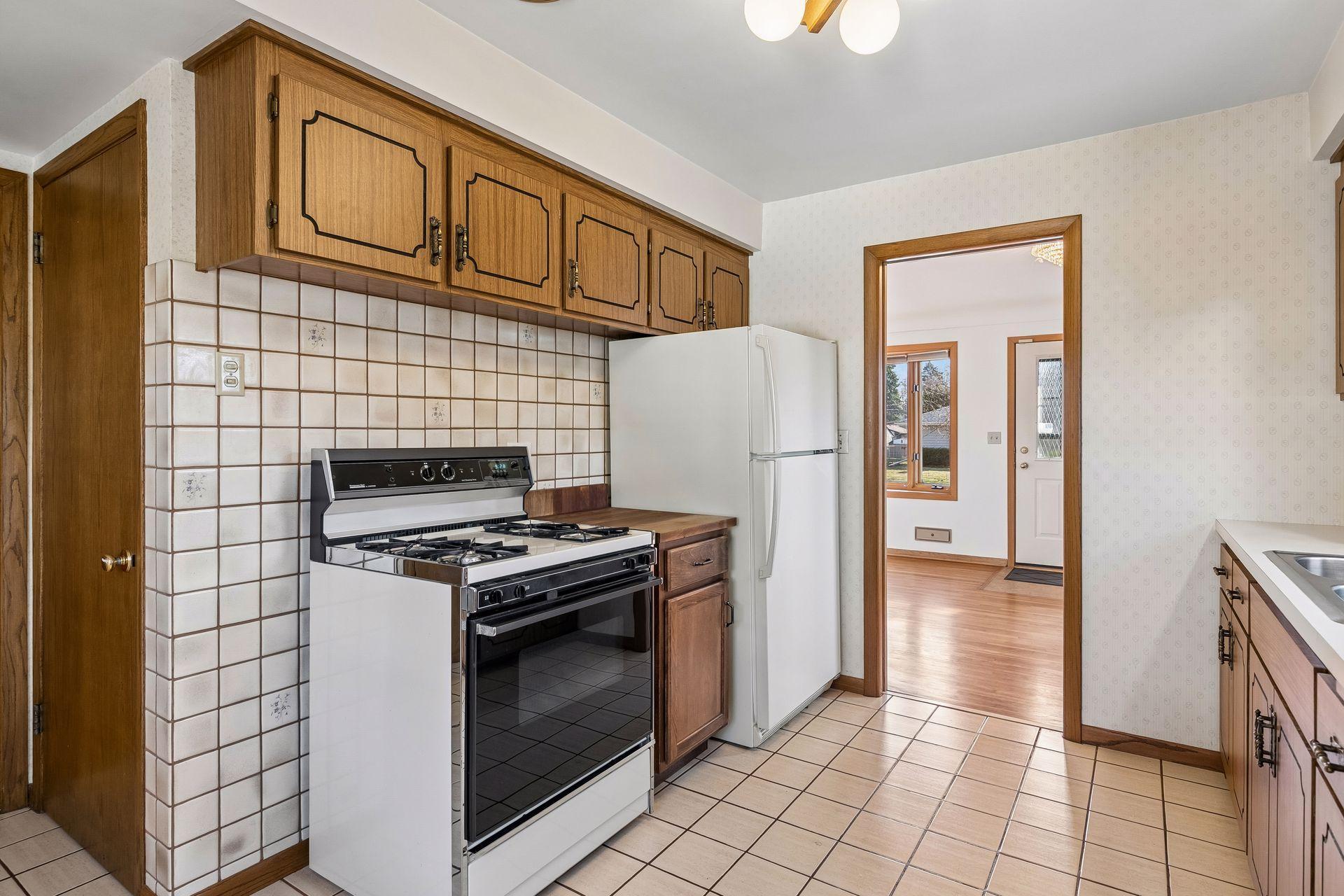 Alternate view of the kitchen highlighting its efficient layout with access to dining space and living room.