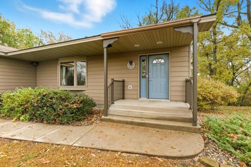 Inviting front porch with maintenance free railing. This property is situated on 1.41 acres surrounded by mature trees offering tons of privacy!