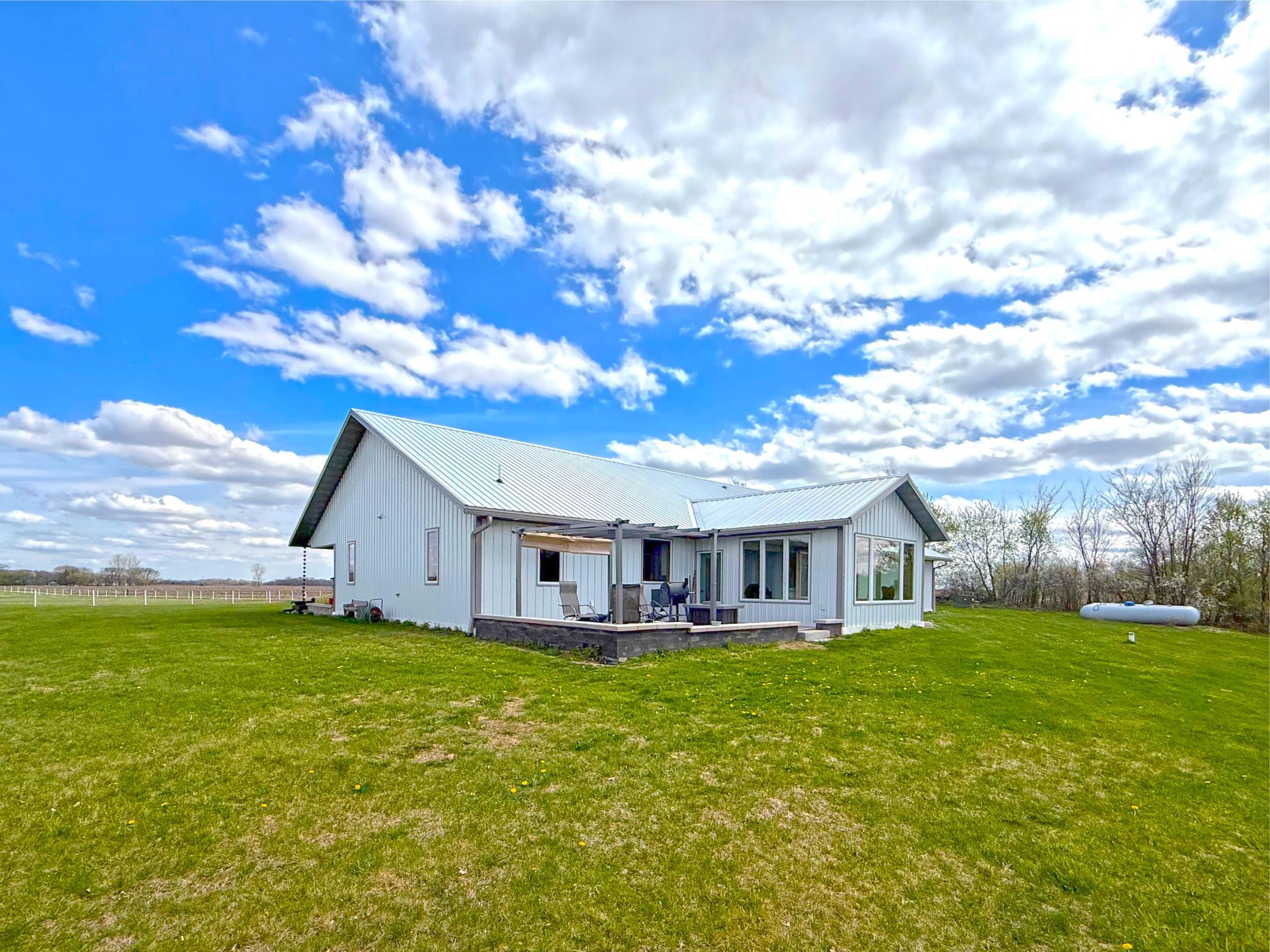 The rear of the home is designed for both relaxation and functionality, featuring a spacious patio that creates the perfect setting for outdoor dining and entertaining.