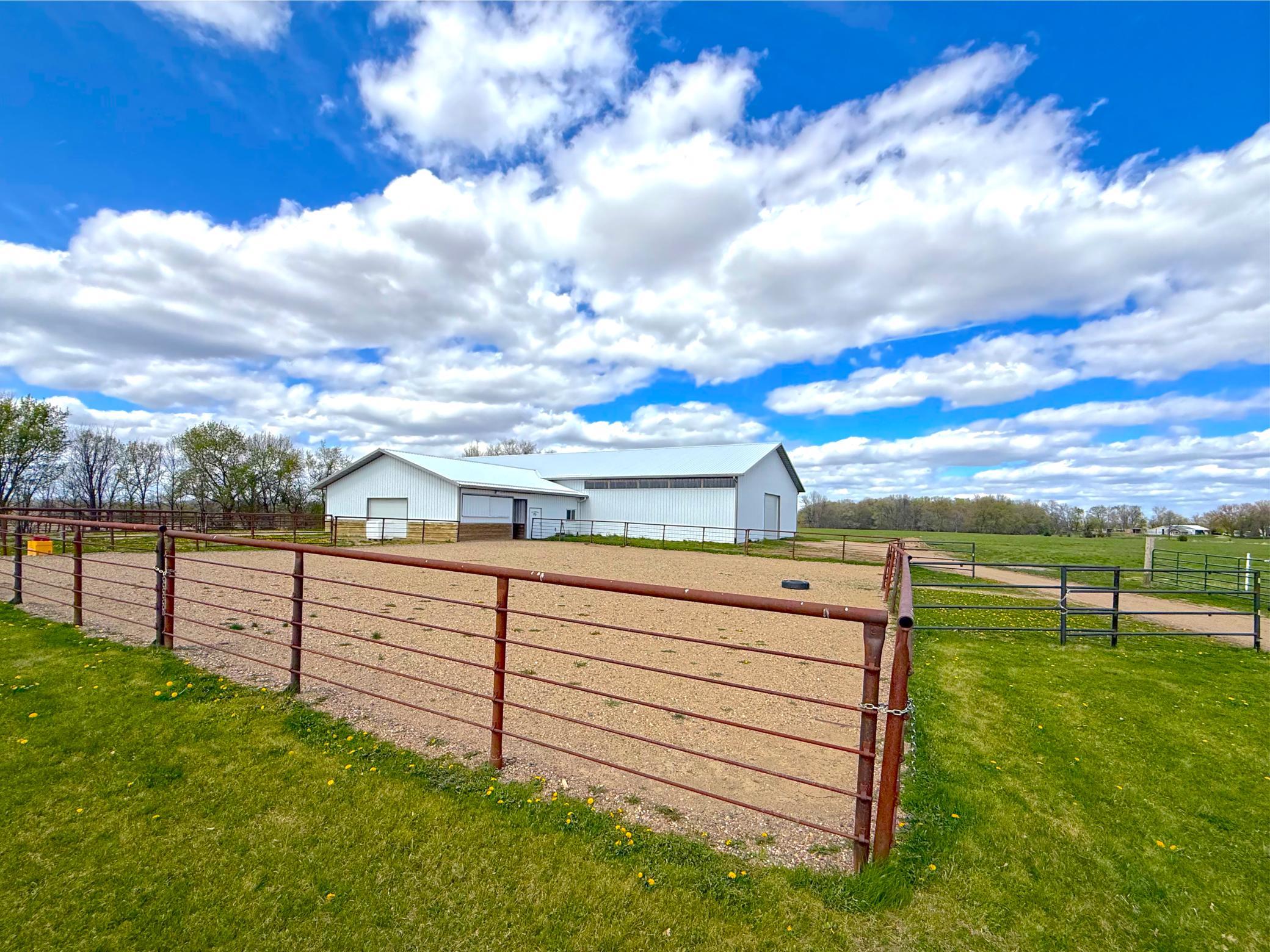The centerpiece of the property is the extraordinary 60x120 pole shed featuring an indoor riding arena, office space, half bathroom, and direct access to three paddocks. Fencing is metal and attractive PVC and electric rope.