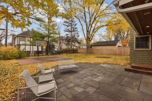 Spacious backyard with a large patio and sport court, perfect for entertaining and outdoor activities.