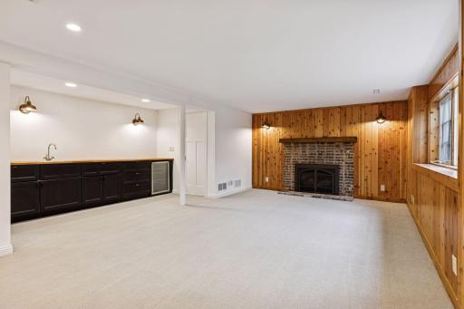 Lower Level family room wood burning fireplace offers a space to unwind, allow comfort in.