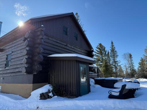 Backside of cabin with exterior entry to rec room and utilities.