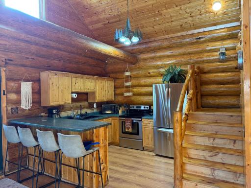 Complete kitchen with stainless steel appliances and a breakfast bar.