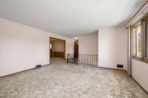 Living Room view with open extra wide staircase to walkout lower level -