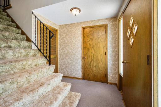 Foyer with access to garage, lower level family room and extra wide staircase to main level!