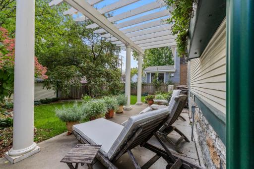 Pergola covered patio overlooking beautifully landscaped back yard