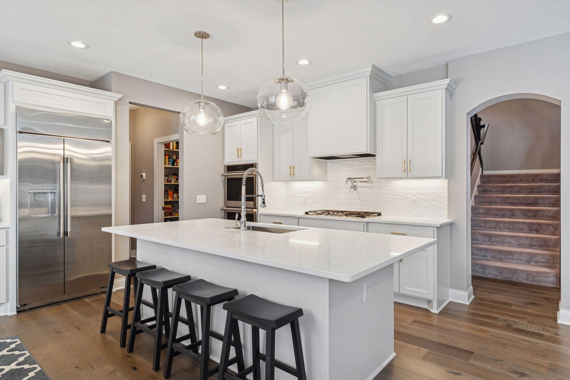 Renovated kitchen in 2024 with new hardware, lighting and Monogram appliances.