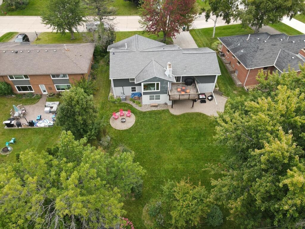 Perfect setting with deck, large paver patio and fire pit in the flat backyard along the creek.