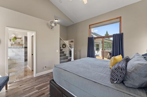 Primary bedroom with access to the deck and large updated closet and beautiful tile bathroom.