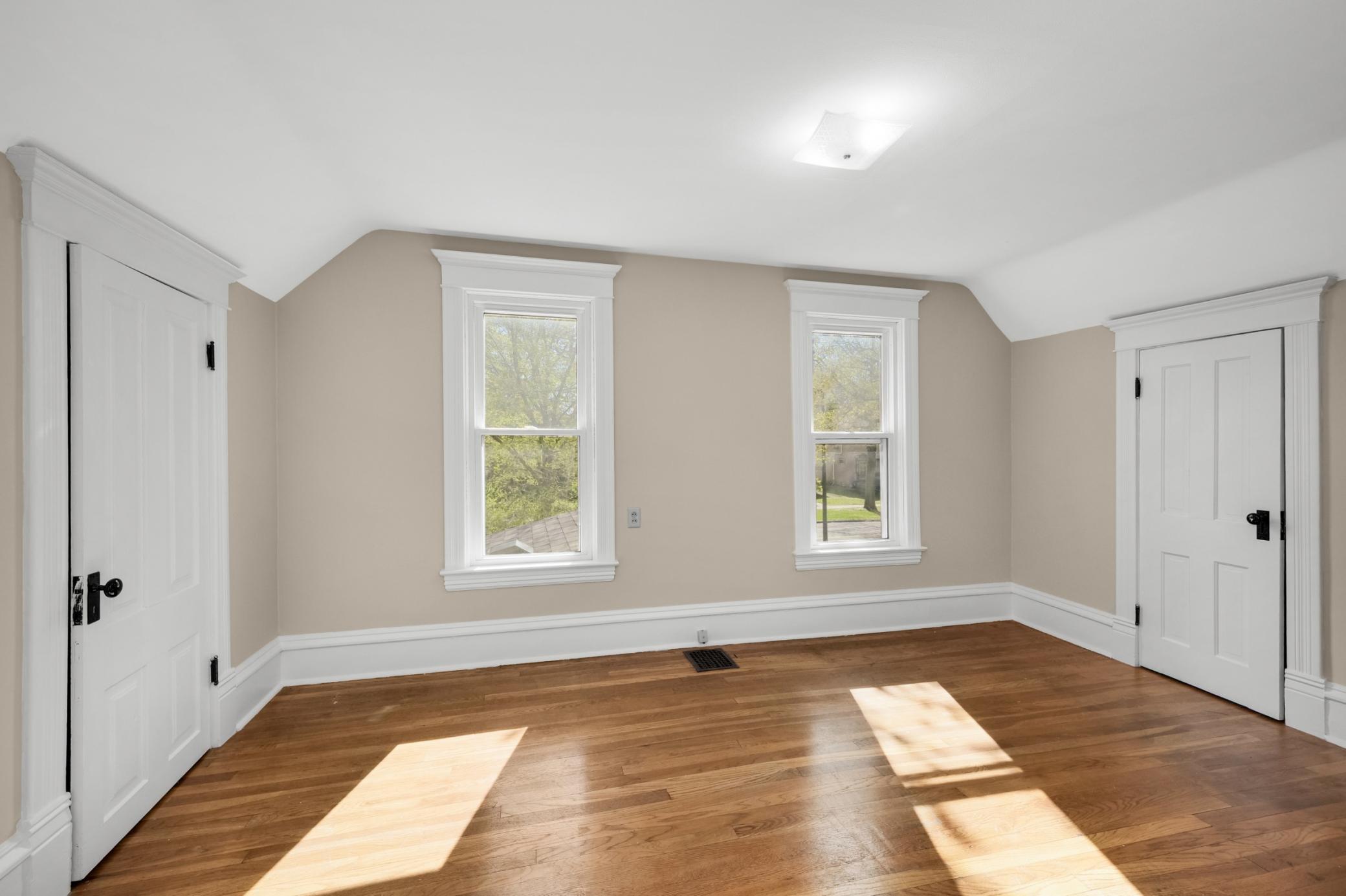 Upper level bedroom with two closets and hardwood floors.
