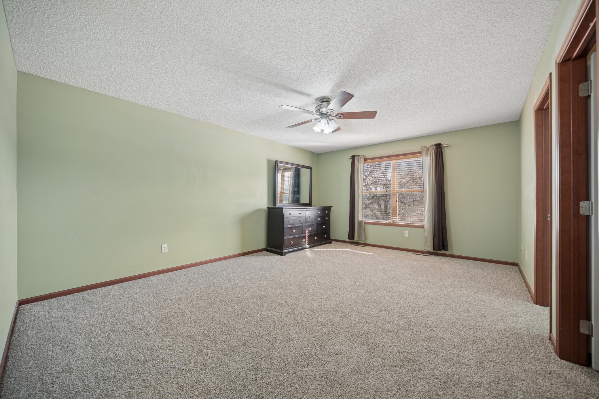 Spacious primary bedroom with generously sized walk-in closet and full private bathroom