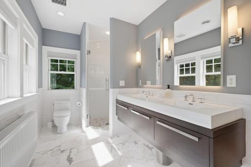 Private 3/4 owner's bath with heated tile floors, dual vanities and beautiful tilework, double drawer pull outs and floating sink.