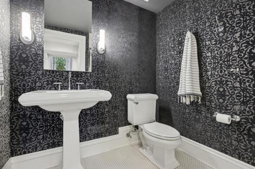 Lower level 3/4 bathroom is a stunner with tiled floors, fabric wall covering and updated fixtures.