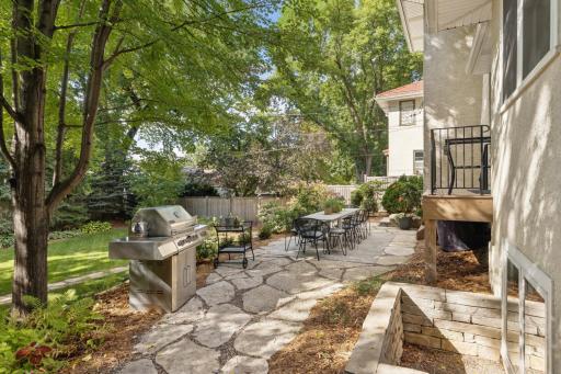 View of stone walkway that winds from the front firepit seating nook to the rear terrace area.
