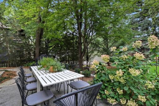 Patio table and view in background of detached two-car garage and new driveway.