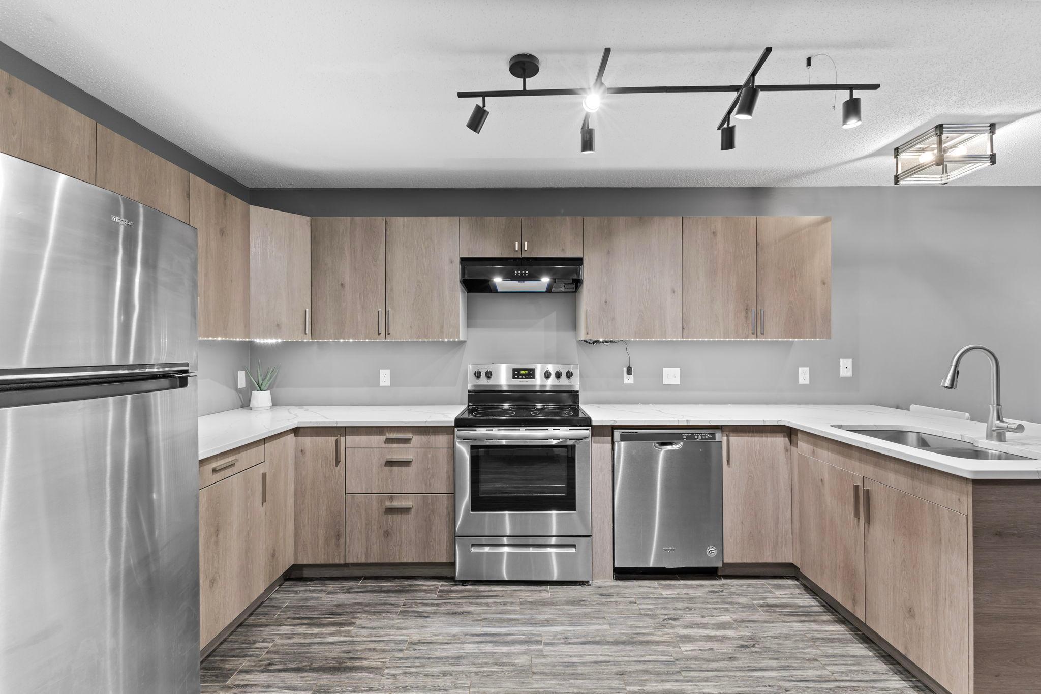 The updated kitchen features stainless steel appliances, newer soft-close cabinetry and drawers, and beautiful quartz countertops.