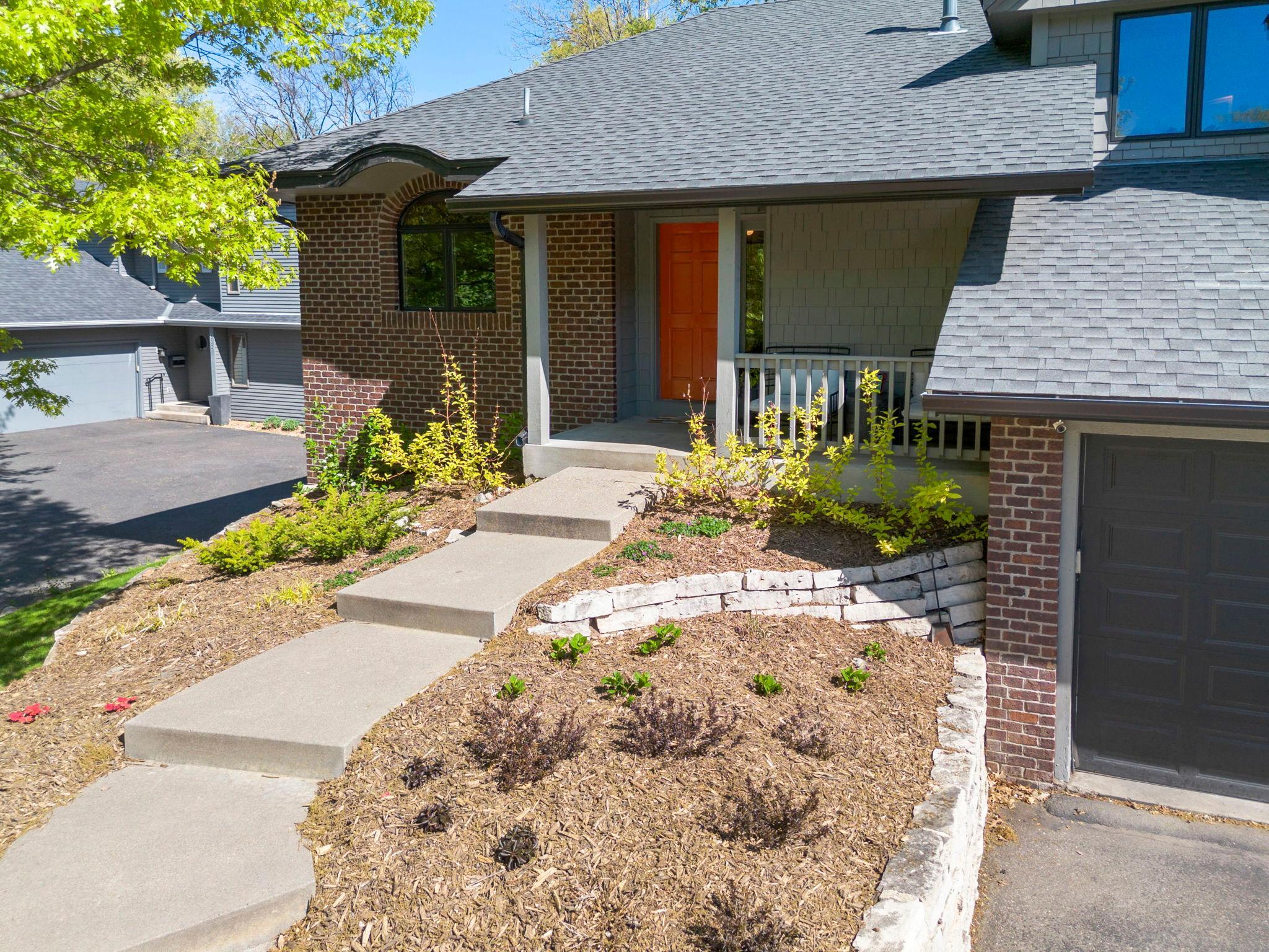Professional landscaping and a cozy front porch create a welcoming entry.