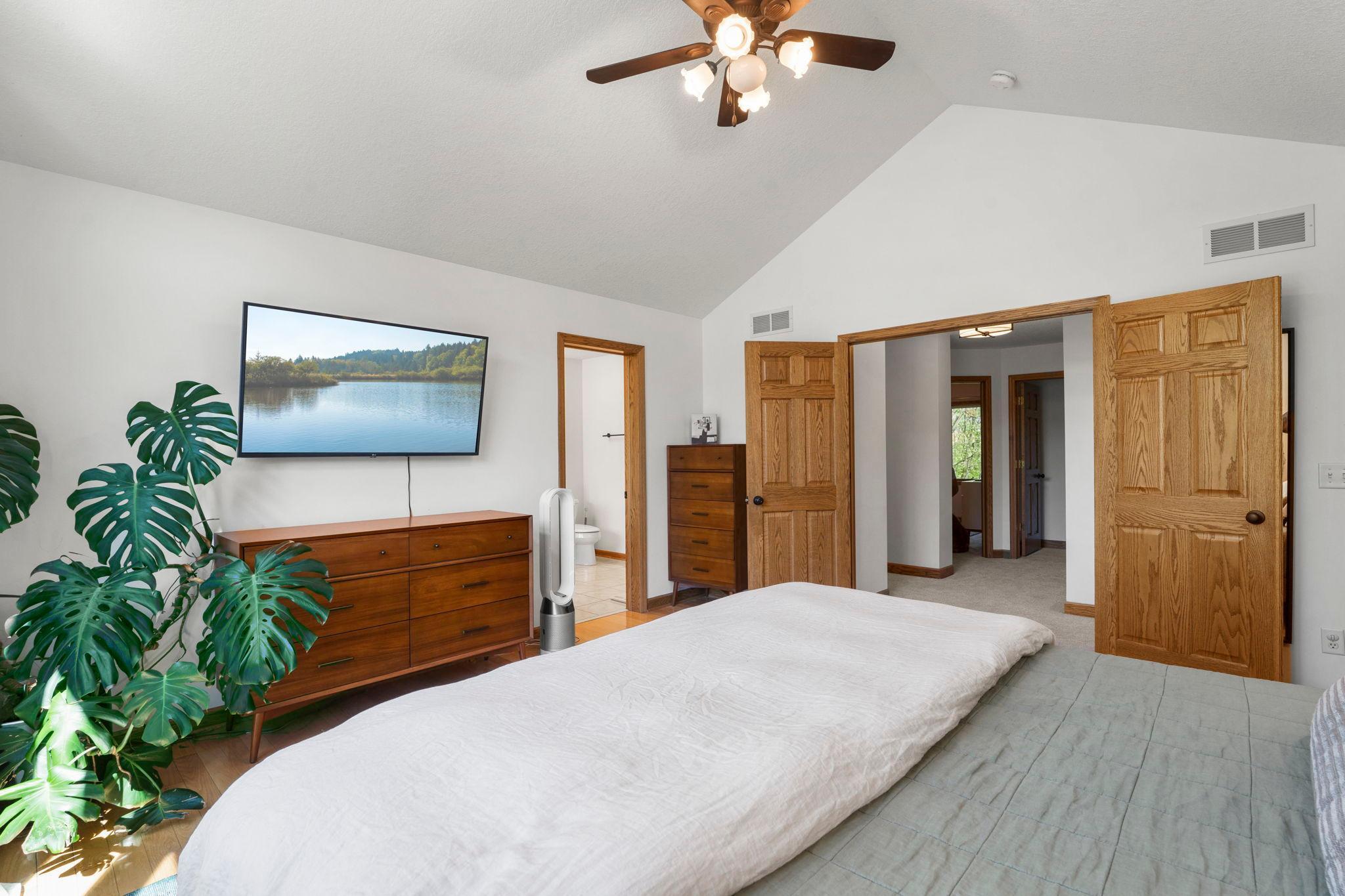 Primary suite has vaulted ceilings and double solid wood panel double doors.