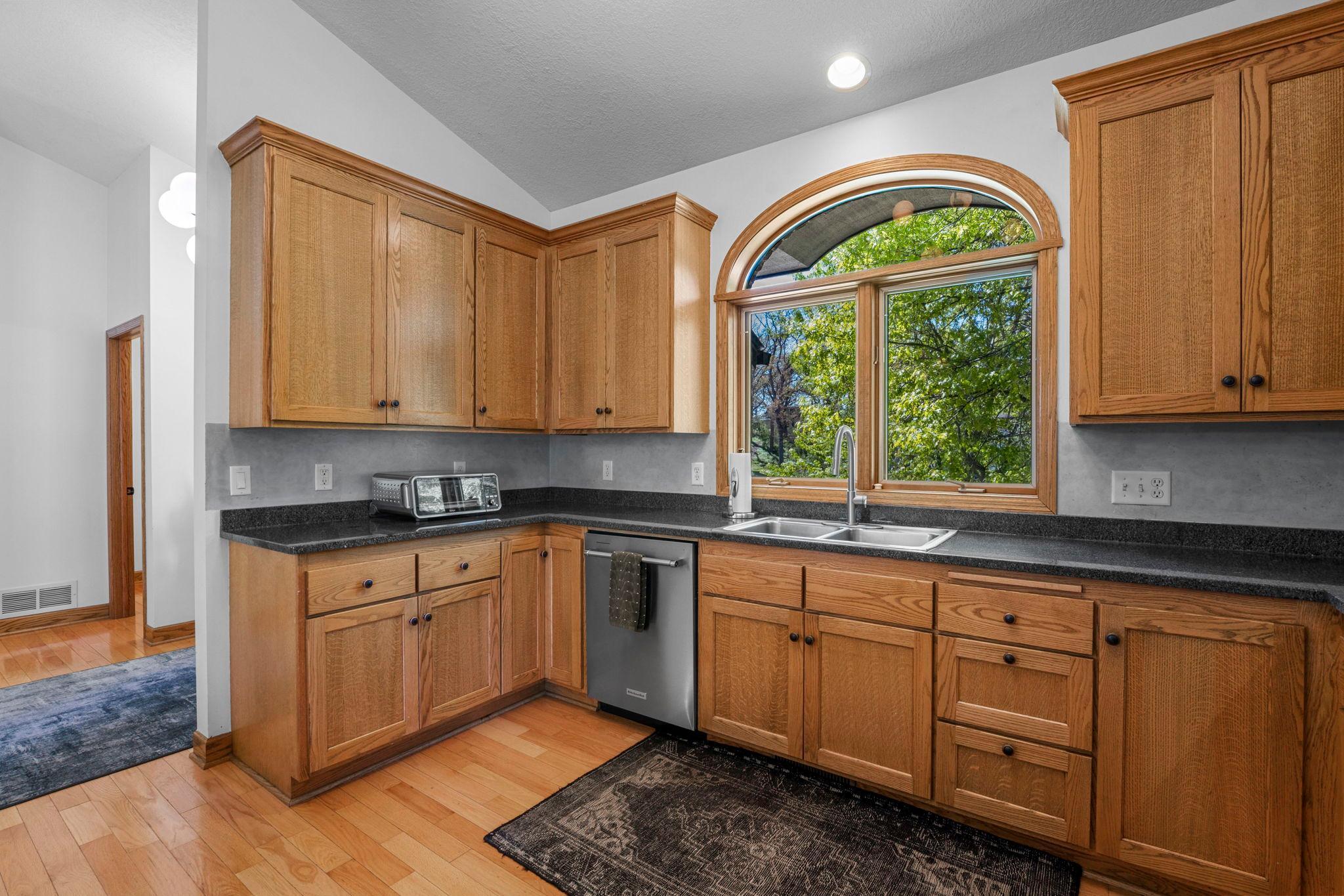 Bright kitchen with craftsman styled cabinetry features tons of storage and recessed lighting.