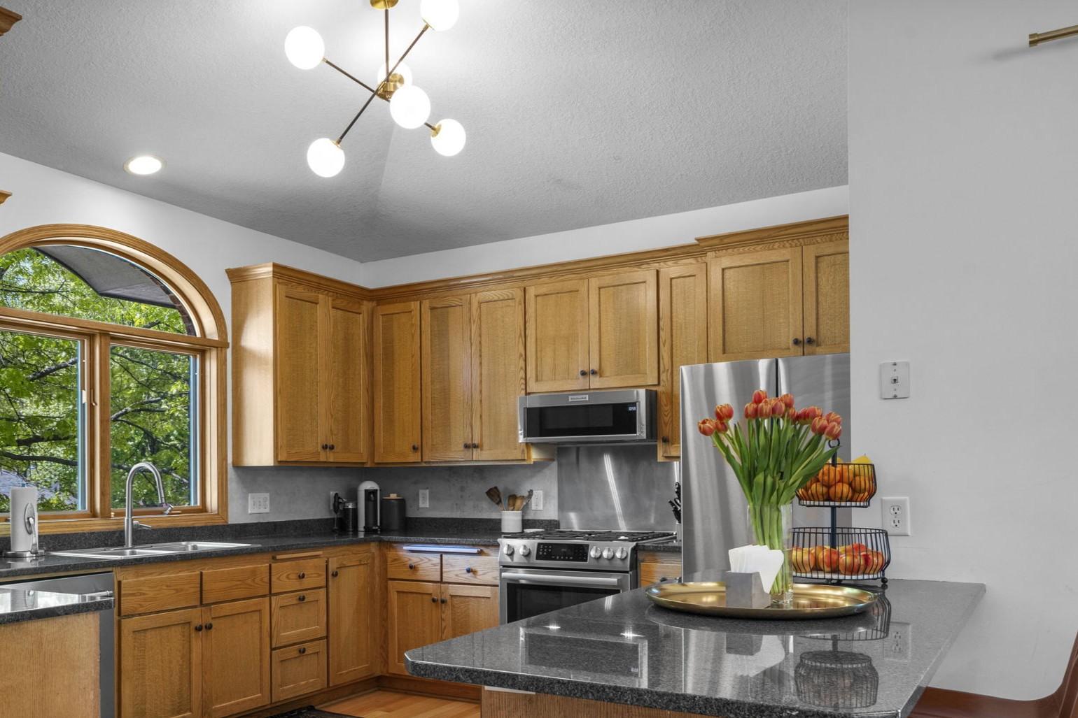 Light filled kitchen with tons of storage, quartz countertops, custom lighting and stainless appliances (new range being installed in June)