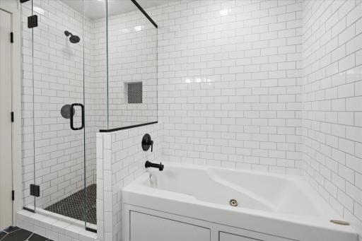 Beautiful, tiled shower, flooring and tub surround.