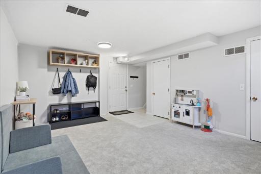 Retreat to the lower level where you'll find the family room. The door to the left leads to the garage. Door to the right is the mechanical room and laundry area.