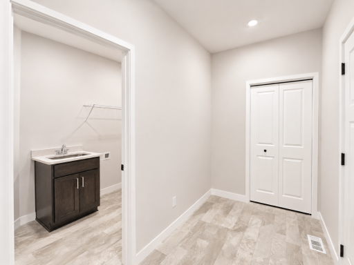 Functional mudroom off the garage offers a convenient drop zone with nearby storage and direct access to the laundry room.