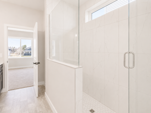 Elegant walk-in shower with floor-to-ceiling tile, frameless glass enclosure, and stylish hexagon tile flooring for a luxurious spa-like feel.