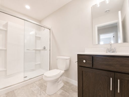 Finished lower-level bathroom featuring a walk-in shower with glass doors, modern vanity, and quality finishes for guests or everyday convenience.