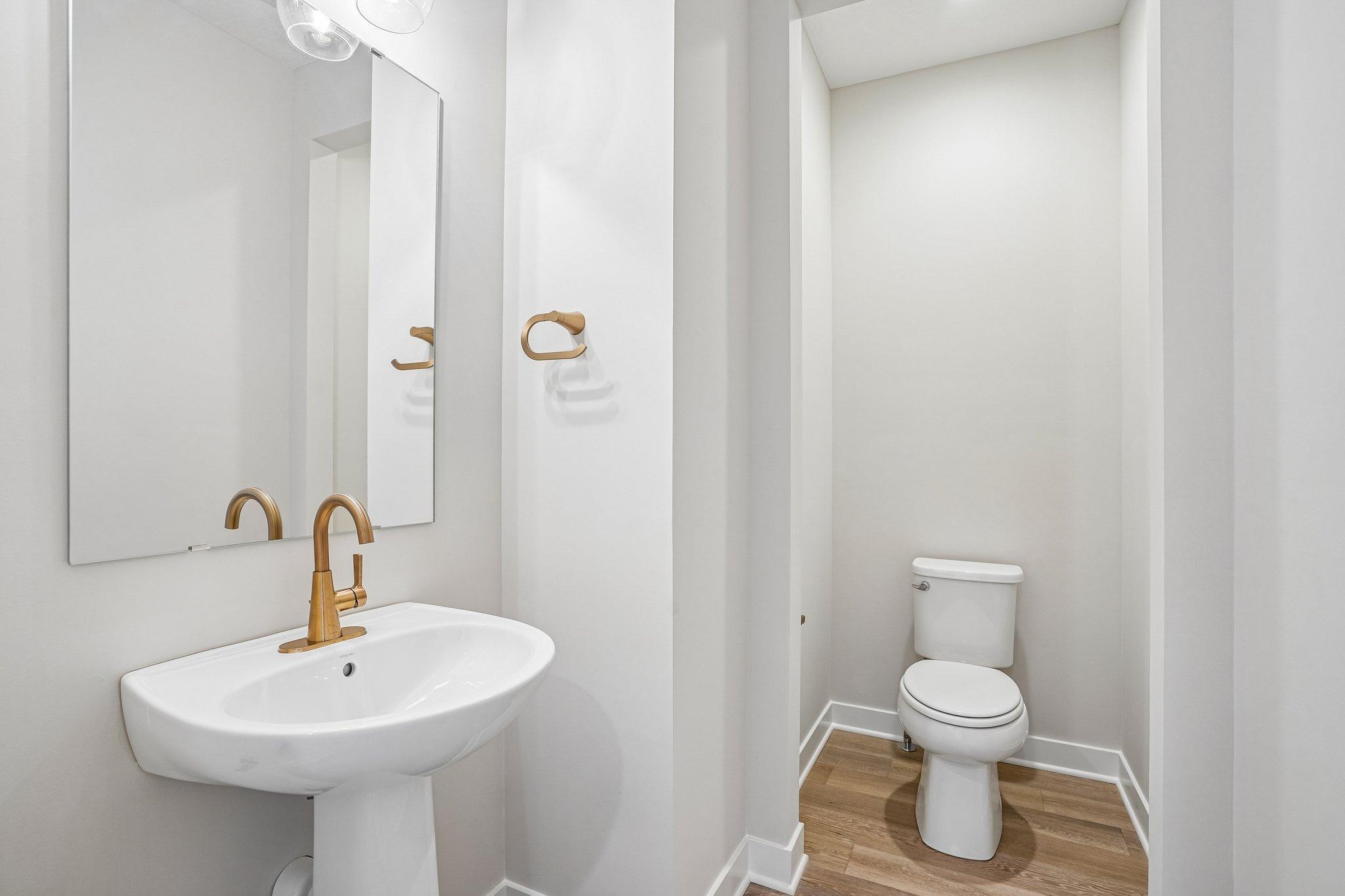 Tucked powder bath on the main level with gorgeous bronze fixtures.