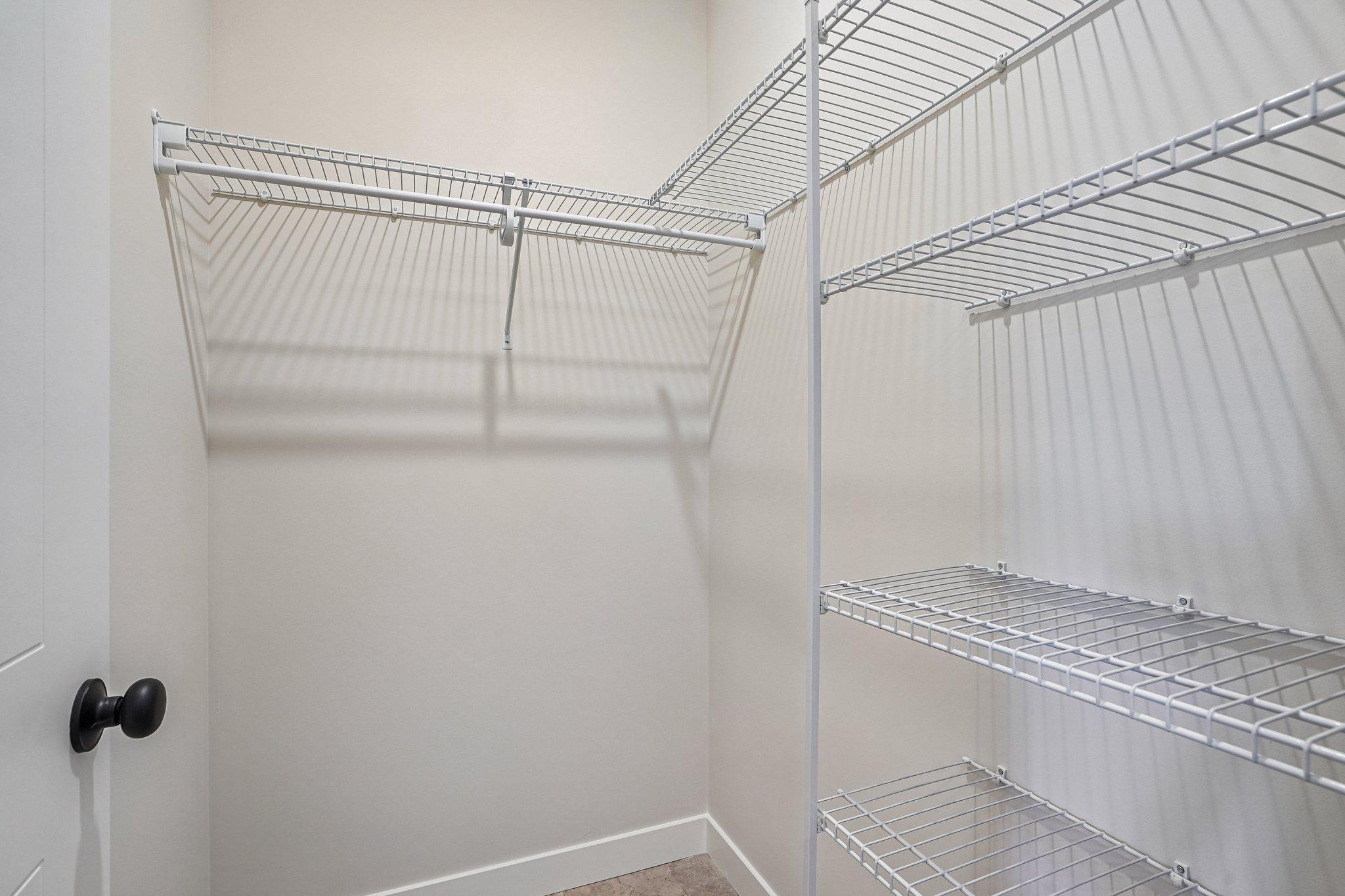 Walk in closet off the mudroom with shelving for ample storage and organization.
