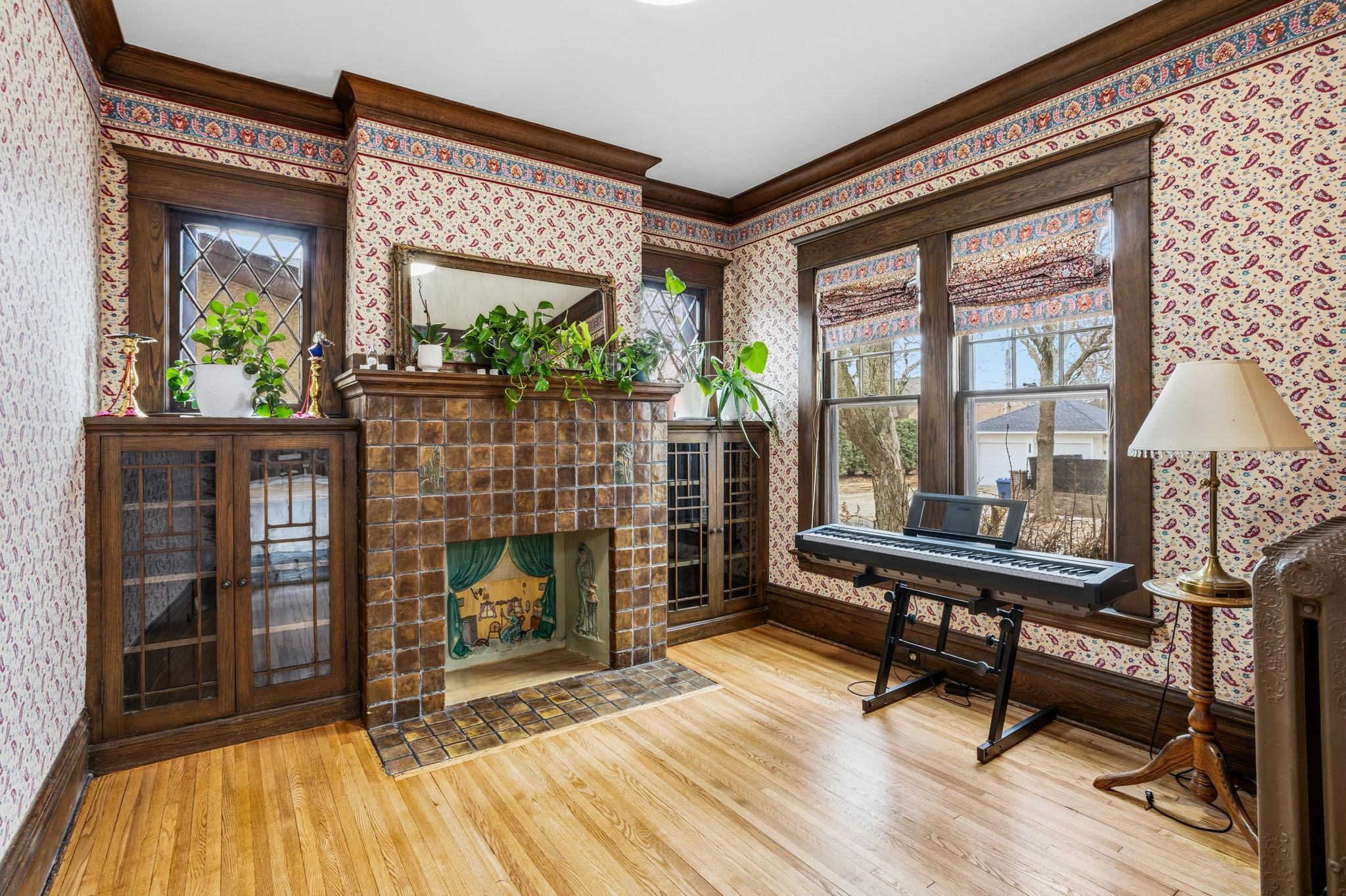 Cozy library with built in bookcases and a decorative fireplace.