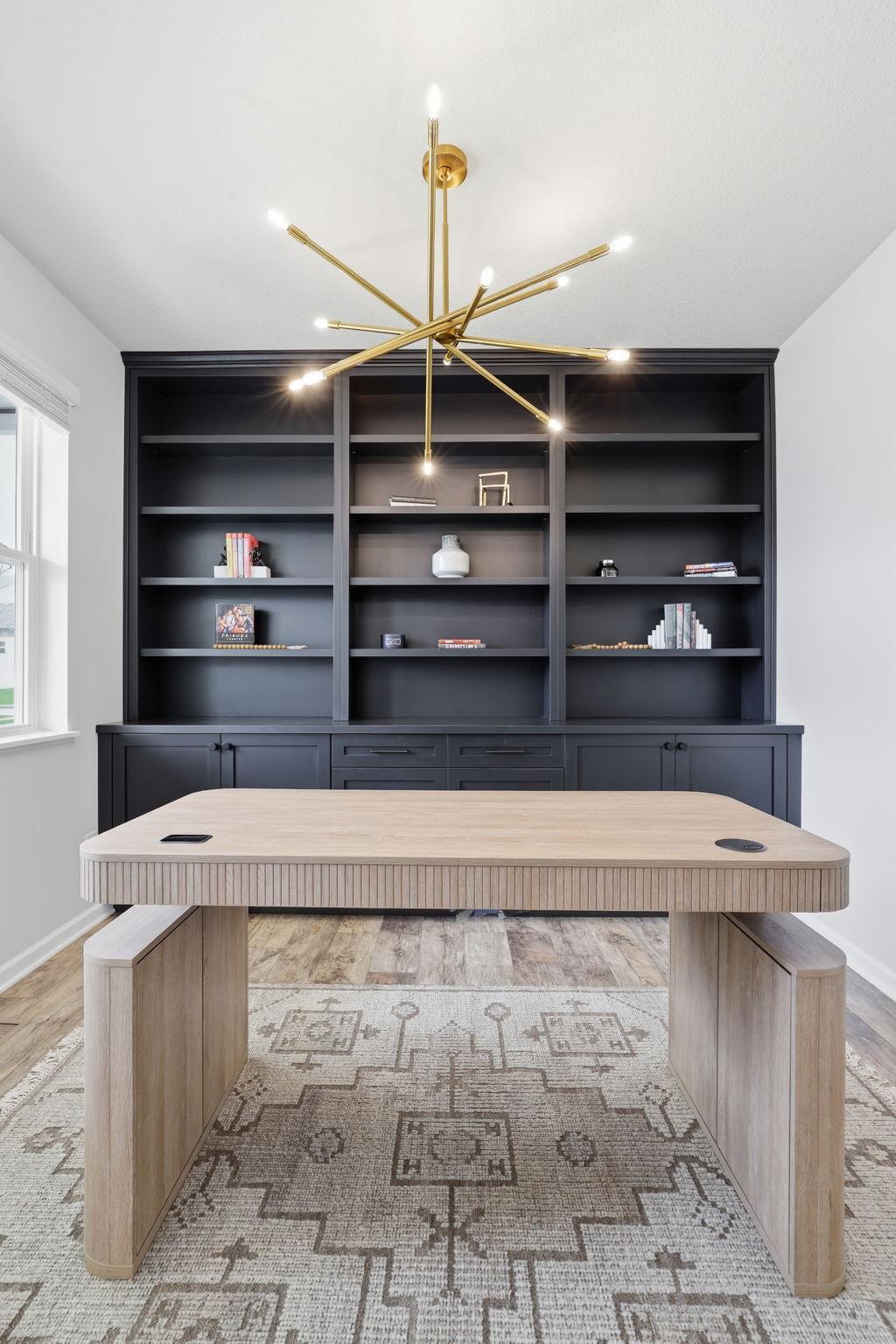 Front office with NEW built-ins and NEW light fixture (2025) offers stylish storage and a functional workspace.