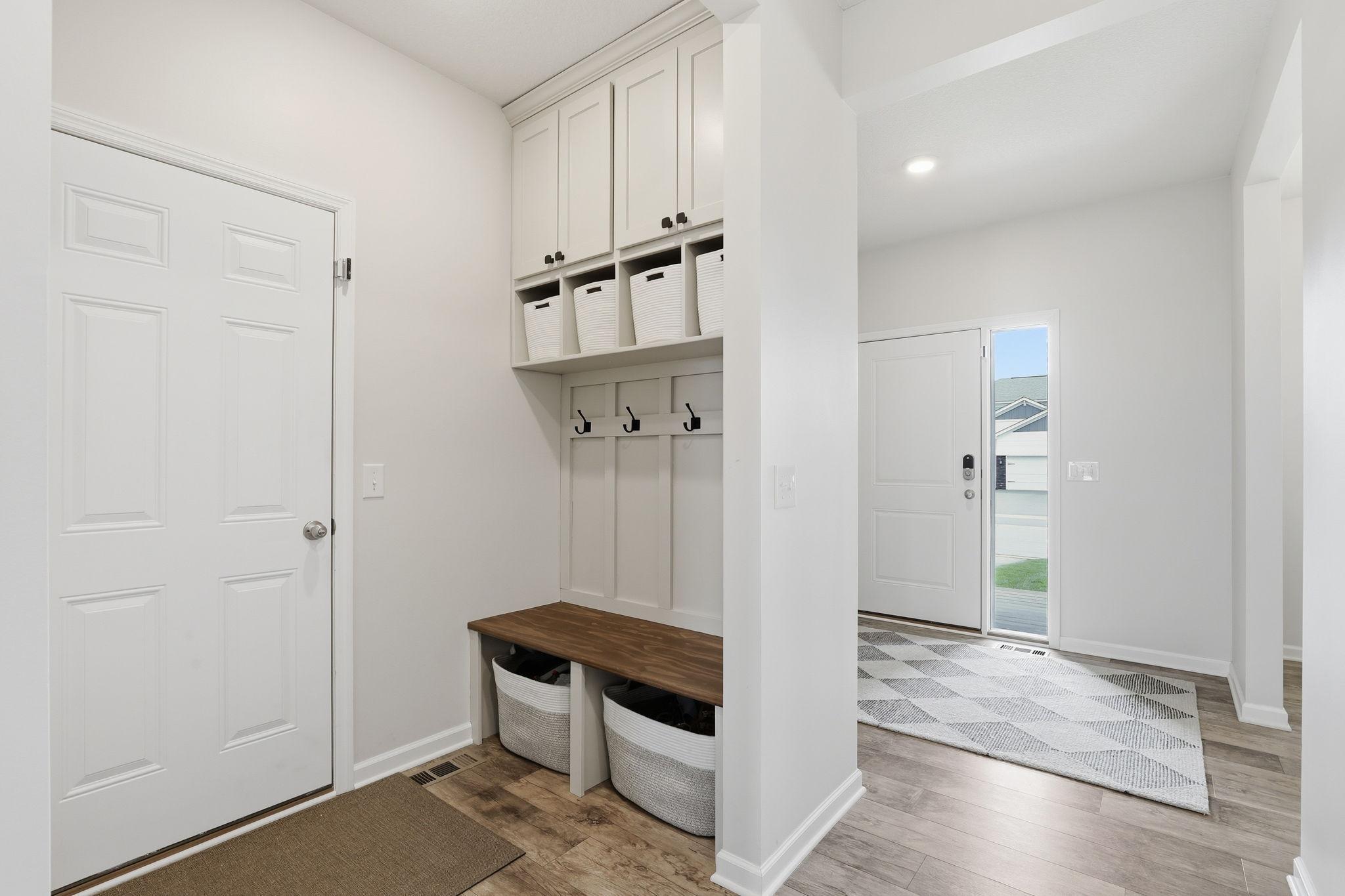 Mud room features NEW built-ins (2023) and fresh paint for stylish everyday organization.