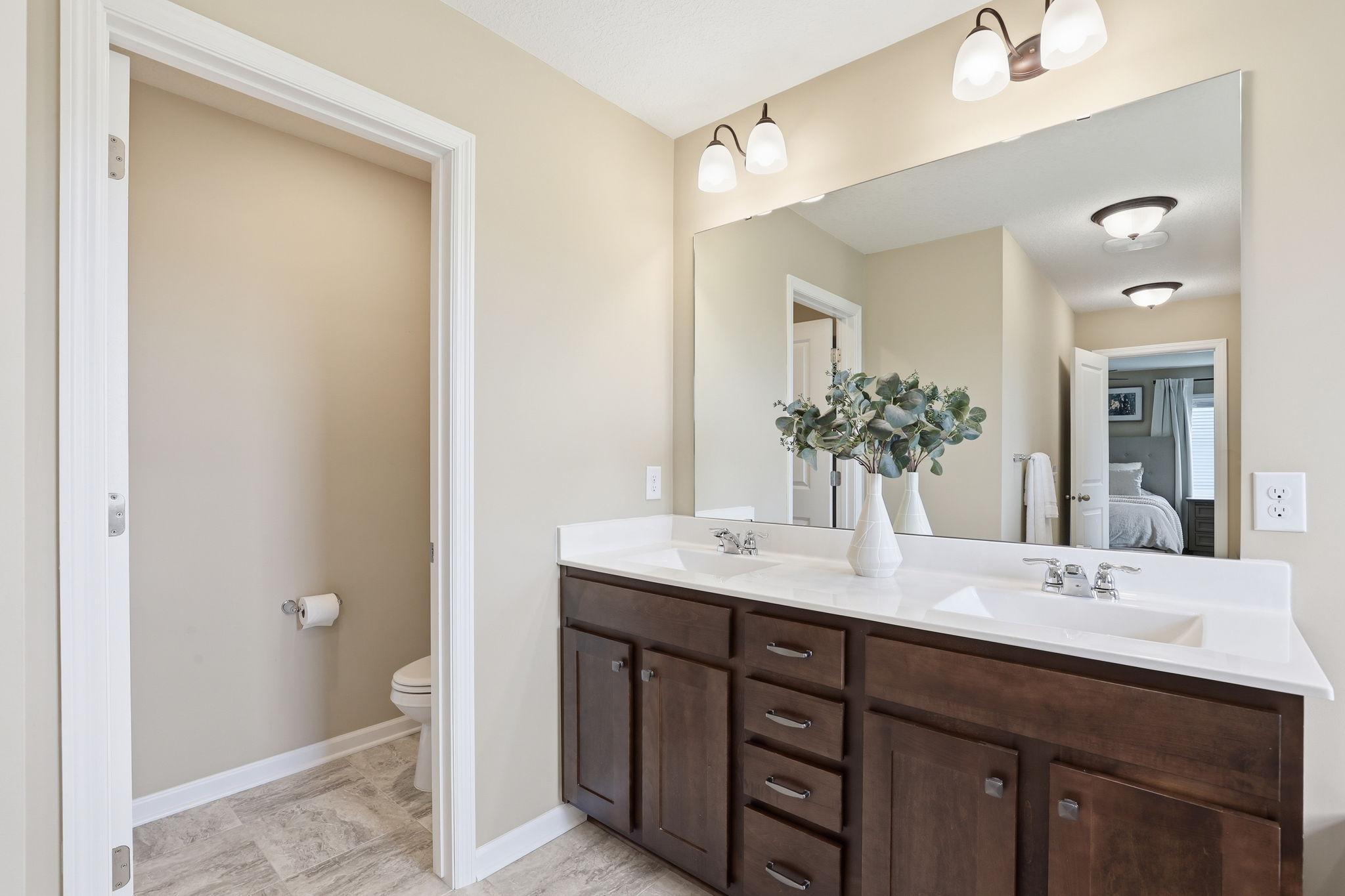 Double vanity for added convenience and a separate toilet room for enhanced privacy and functionality.