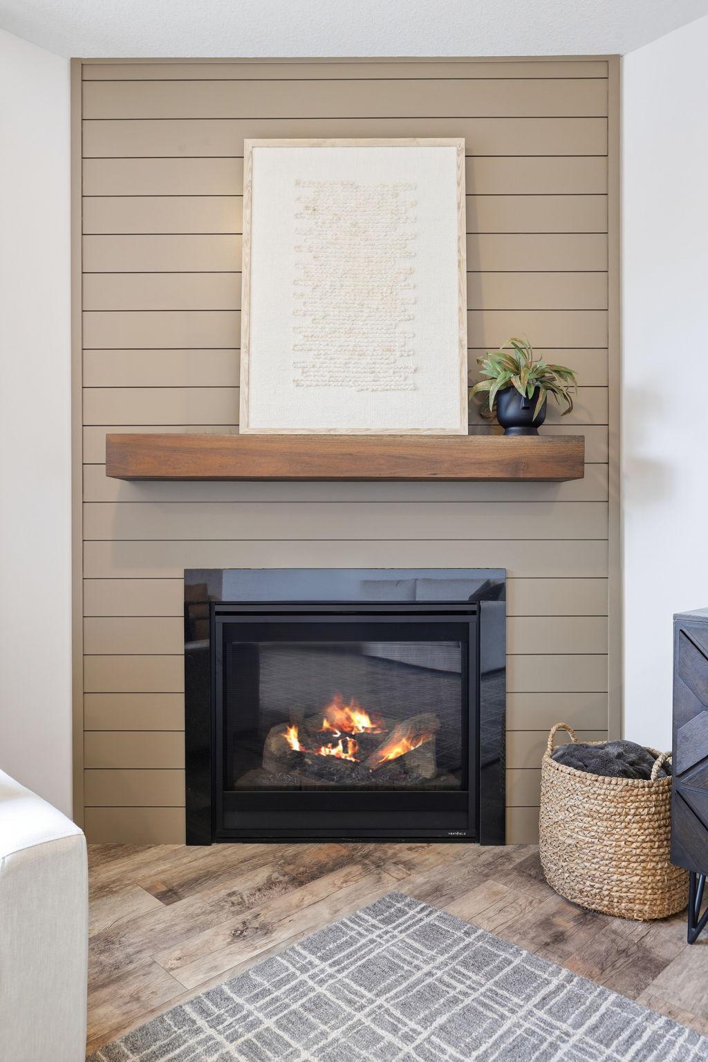 Shiplap accent wall featuring a gas fireplace adds warmth and character.