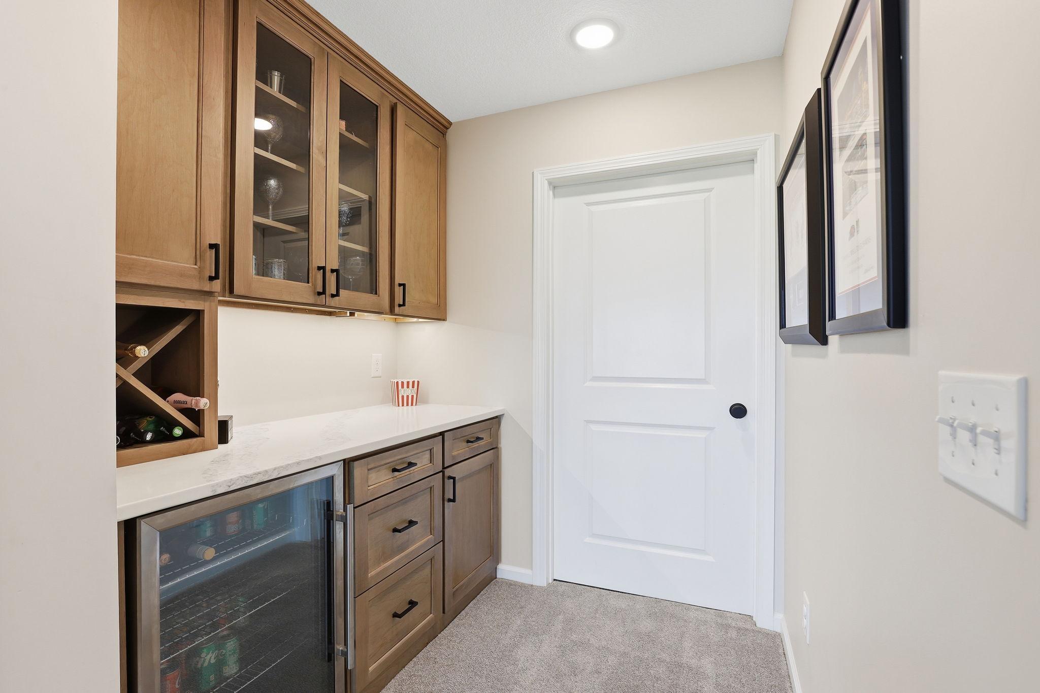 Lower-level dry bar featuring a quartz countertop, offering a stylish and functional space for entertaining and gatherings.