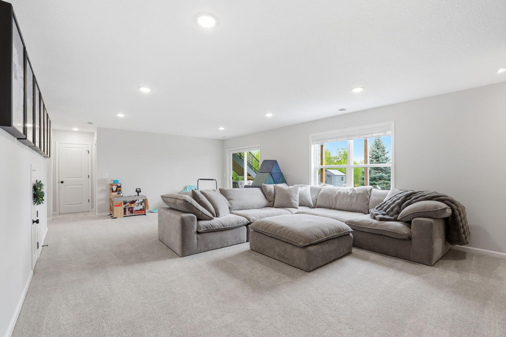Finished lower level (2023) featuring a spacious family room, an additional bedroom, a 3/4 bath, and a versatile playroom ideal for recreation or hobbies.