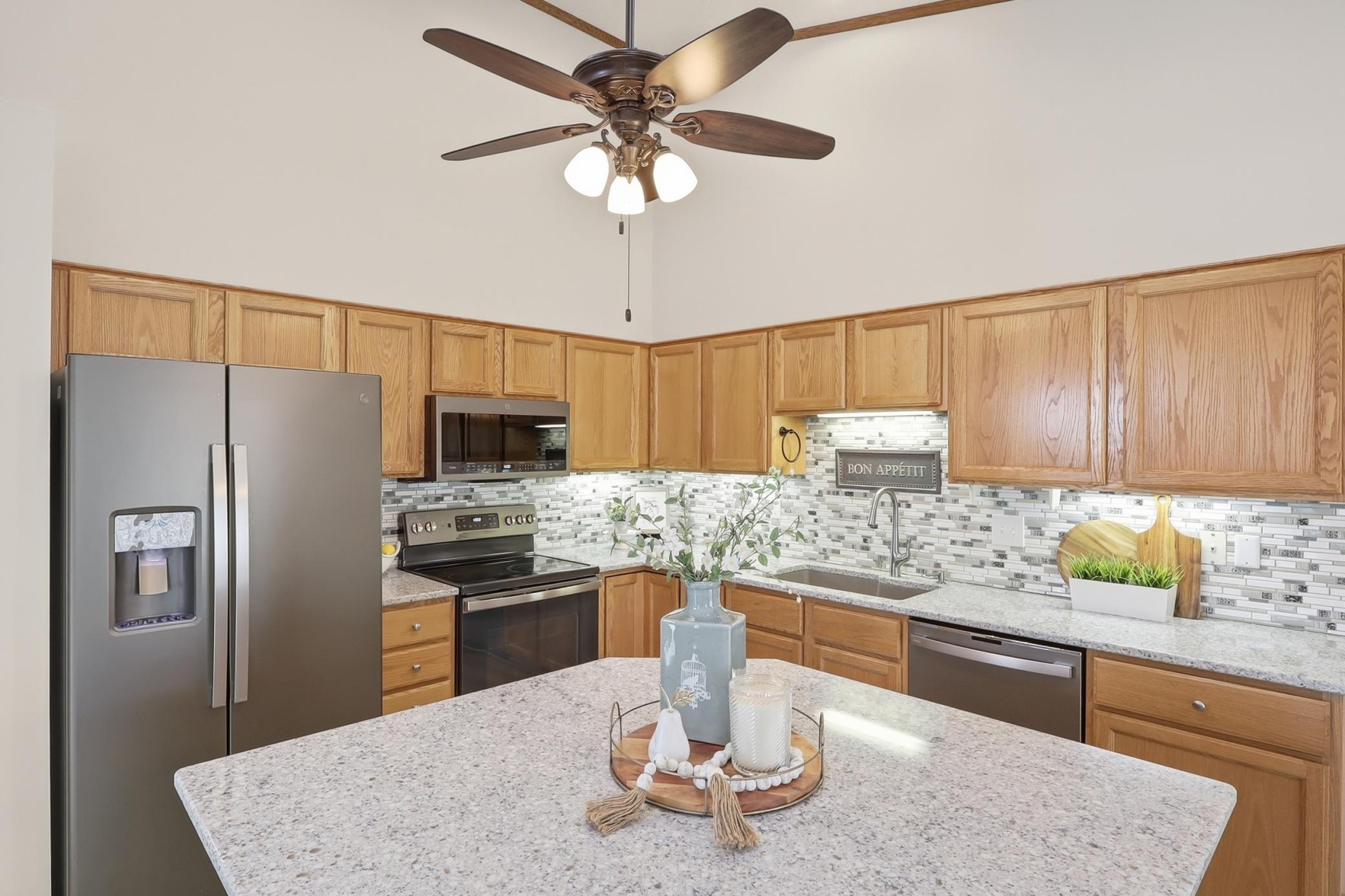 Large center Island with granite, tons of light with new recessed lighting and the ceiling fan.